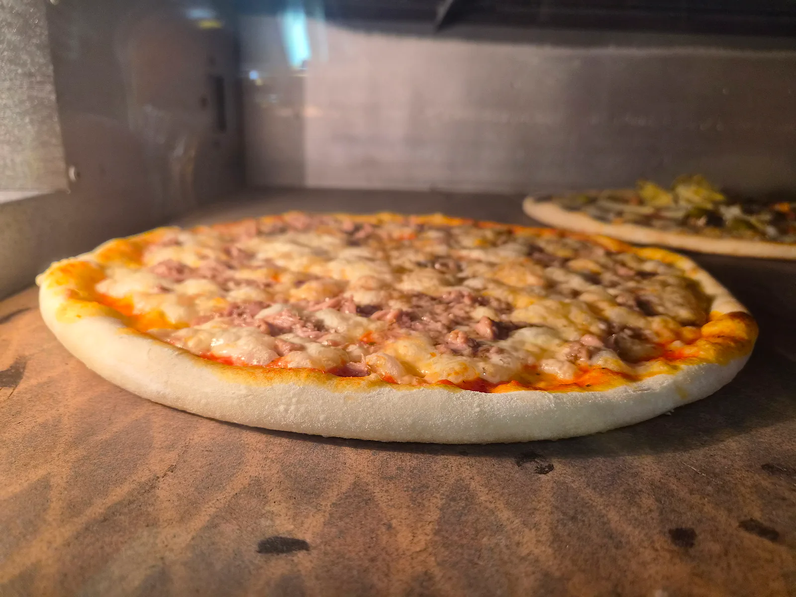 Nygräddad pizza med bubblande ost i ugnen hos Pizzeria Alberto